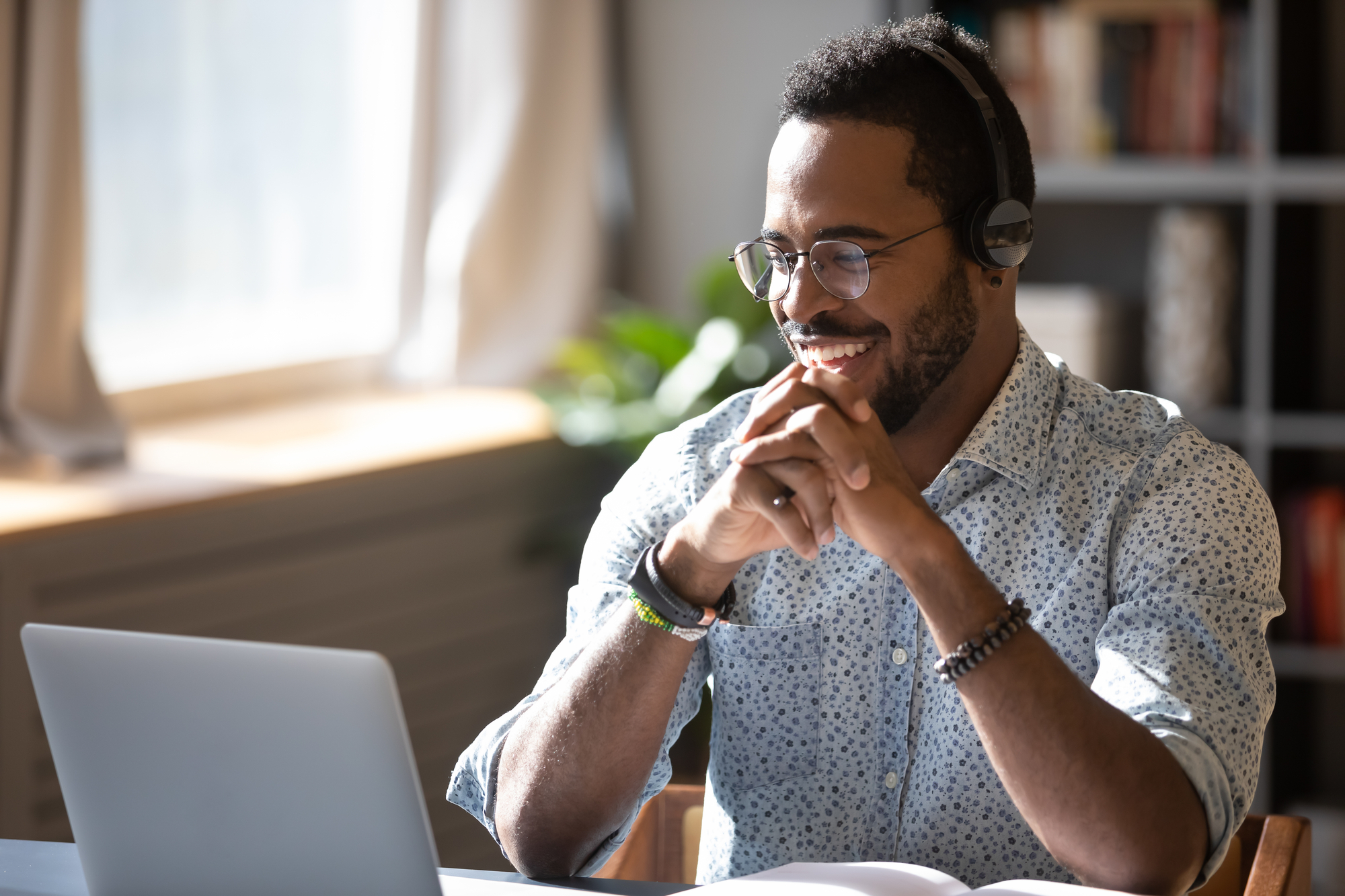 African american man smiling in front of his laptop